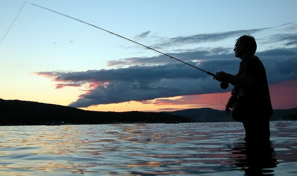 Un hombre pescando tranquilamente en el agua
