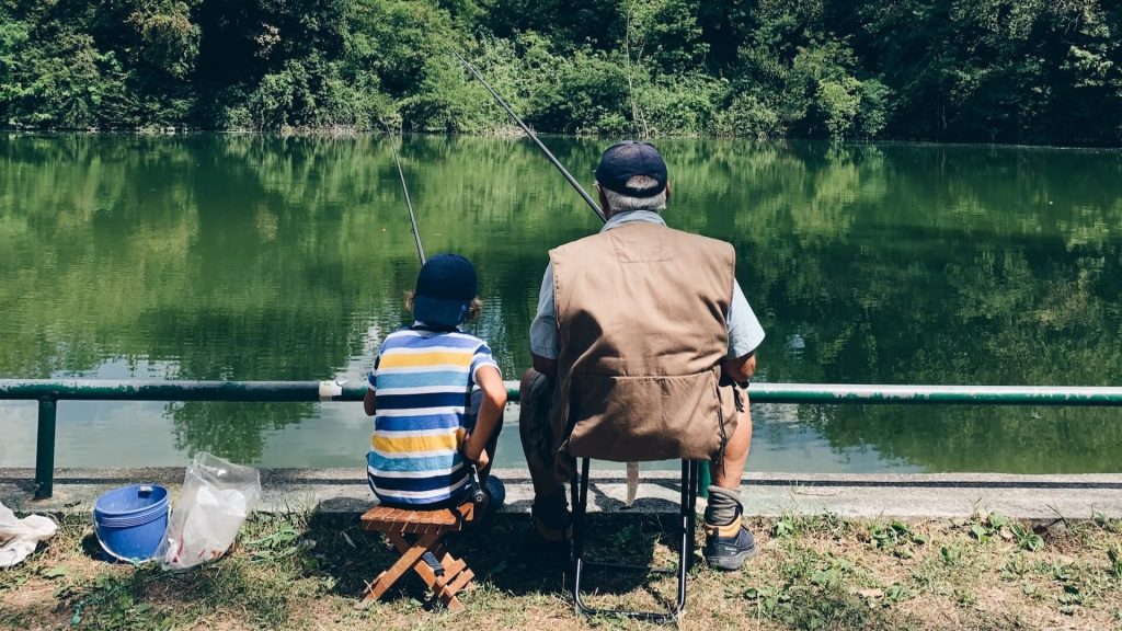 Un abuelo y su nieto pescando en un lago