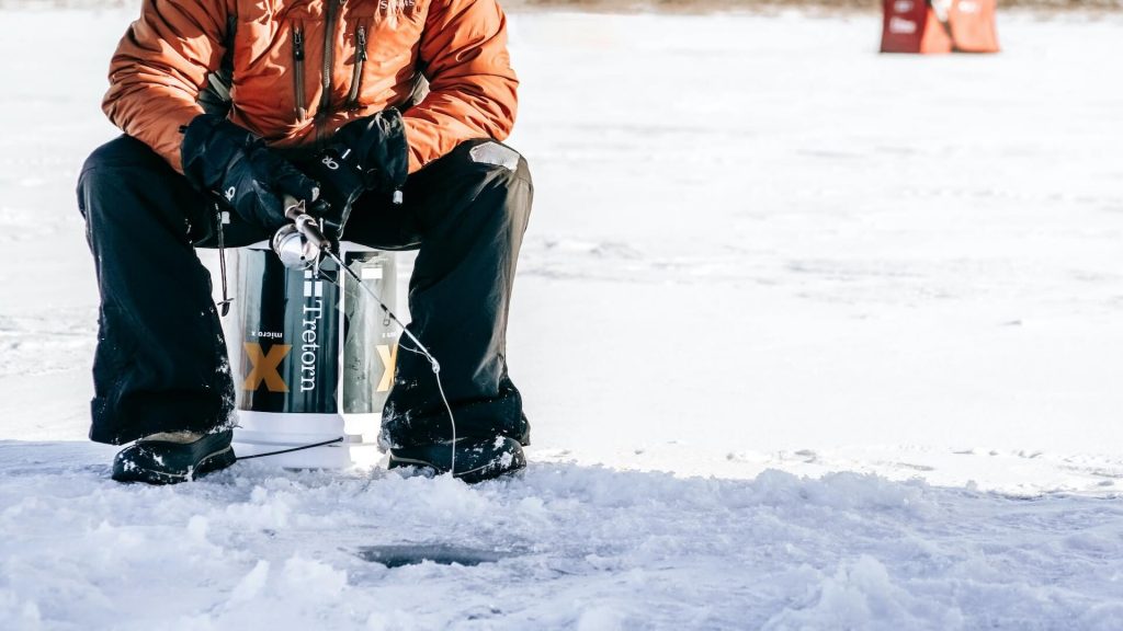 Una persona pesca en hielo en un lago helado